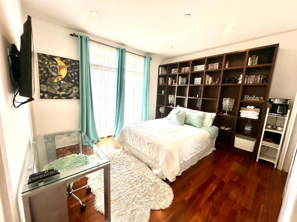 a bedroom with a bed and a television and bookshelves at Your Vacation Home in the Hills of Studio City in Studio City