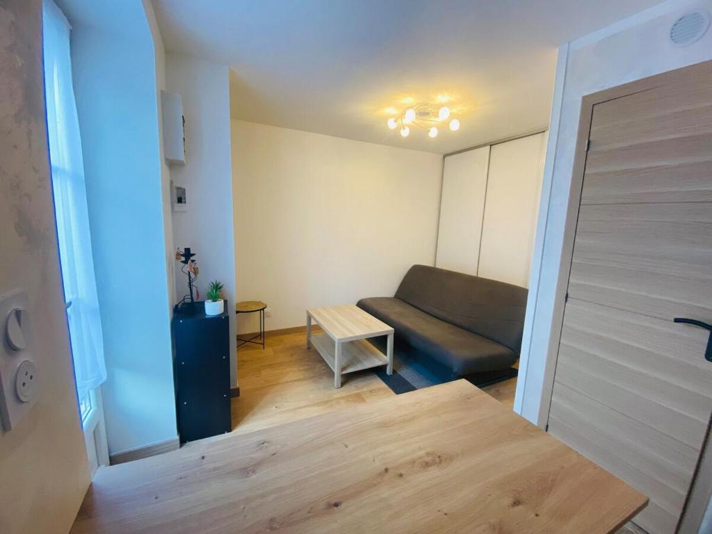 un salon avec un canapé et une table dans l'établissement Studio cosy, à Besançon