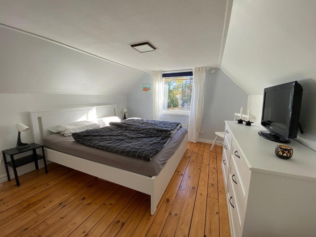 a bedroom with a bed and a flat screen tv at Familien- und hundefreundliches Schwedenhaus in Alleinlage in Moshult