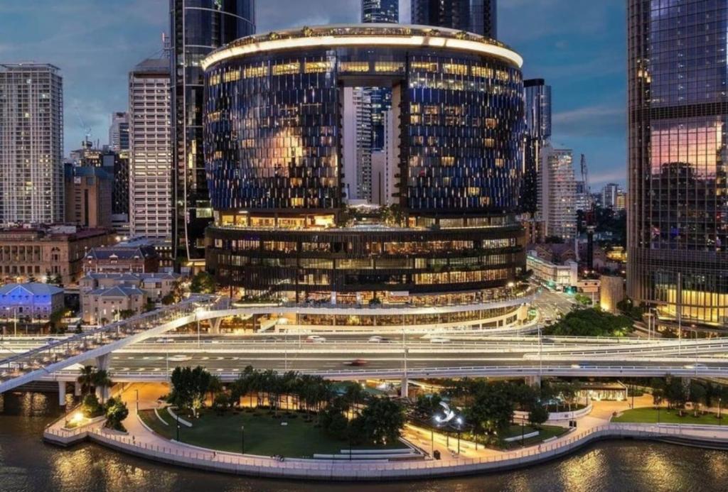a rendering of a large building in a city at night at LVL43 Queens Wharf 1BR Apartment in Brisbane