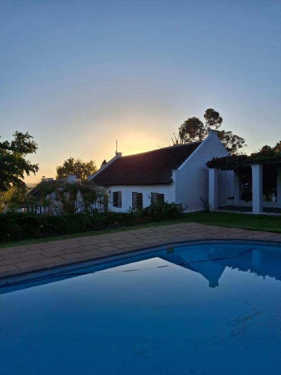 a house and a swimming pool in front of a house at Schalkenbosch Heritage Cottages in Tulbagh
