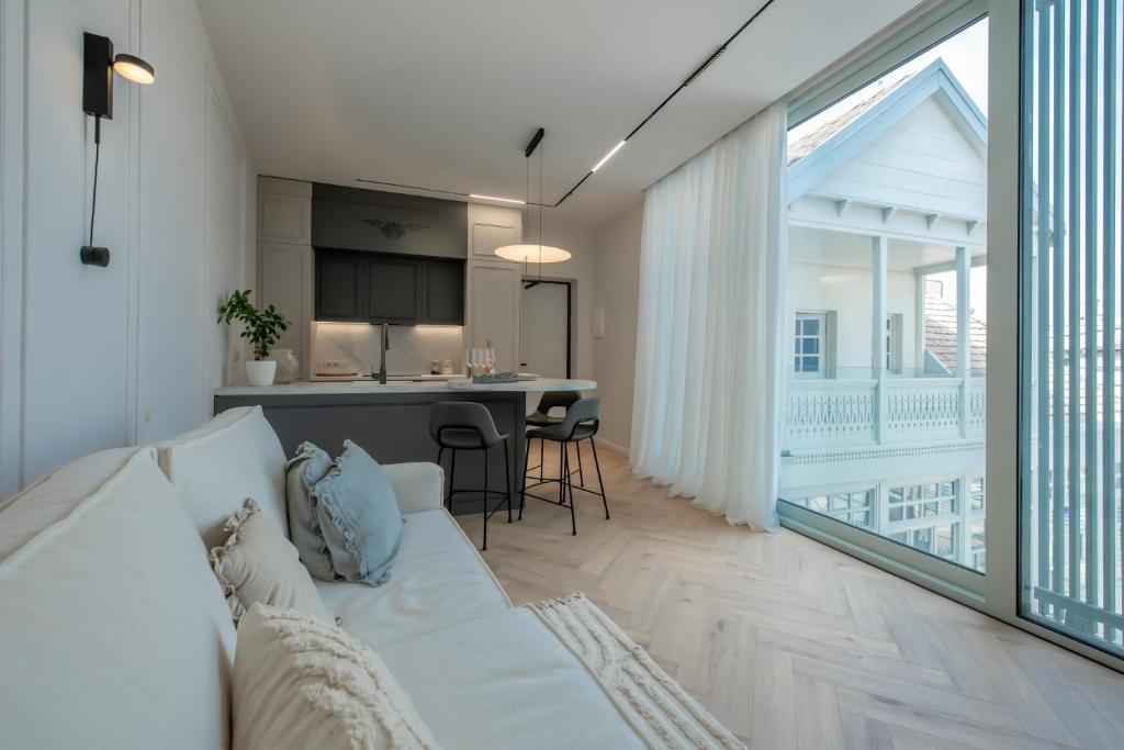 Una sala de estar con un sofá blanco y una cocina. en Metekhi Elegance-Classic Charm in Tbilisi's Heart, en Tiflis