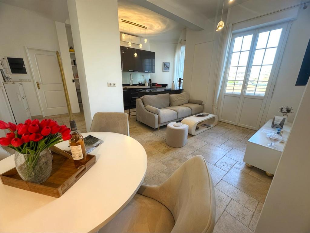 une cuisine et un salon avec une table et des chaises dans l'établissement Appartement T3 grand standing à Juan Les Pins, à Antibes