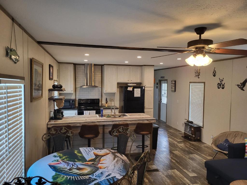 a kitchen with a table and a ceiling fan at The Tackle Box in Many