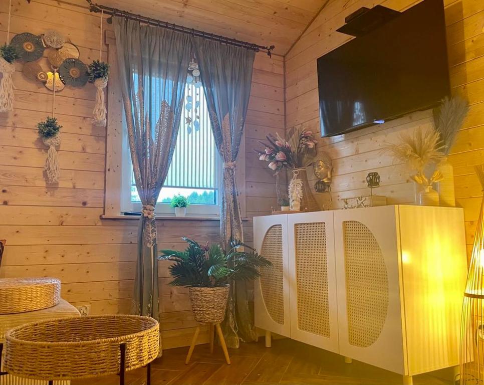 a living room with a tv and a window at Całoroczny "Domeczek na zielonej łące" - w stylu boho in Nowęcin