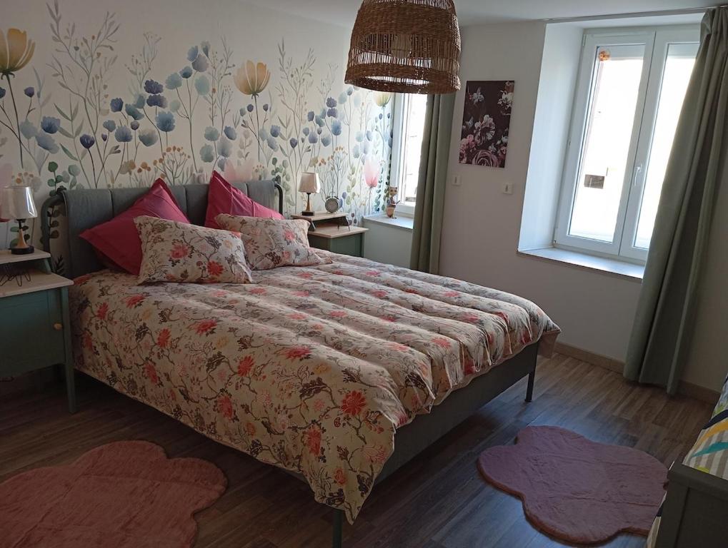 une chambre avec un grand lit avec des oreillers roses dans l'établissement Magnifique hébergement en Rez de jardin, à Joigny-sur-Meuse