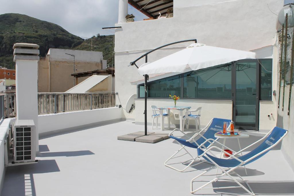 a patio with a table and chairs and an umbrella at Casa Marietta in Lipari