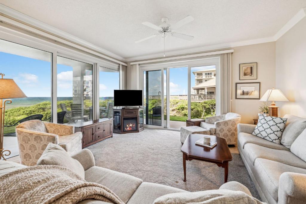 a living room with a couch and a tv at HP 16E Beach Treat by 30A Escapes in Rosemary Beach