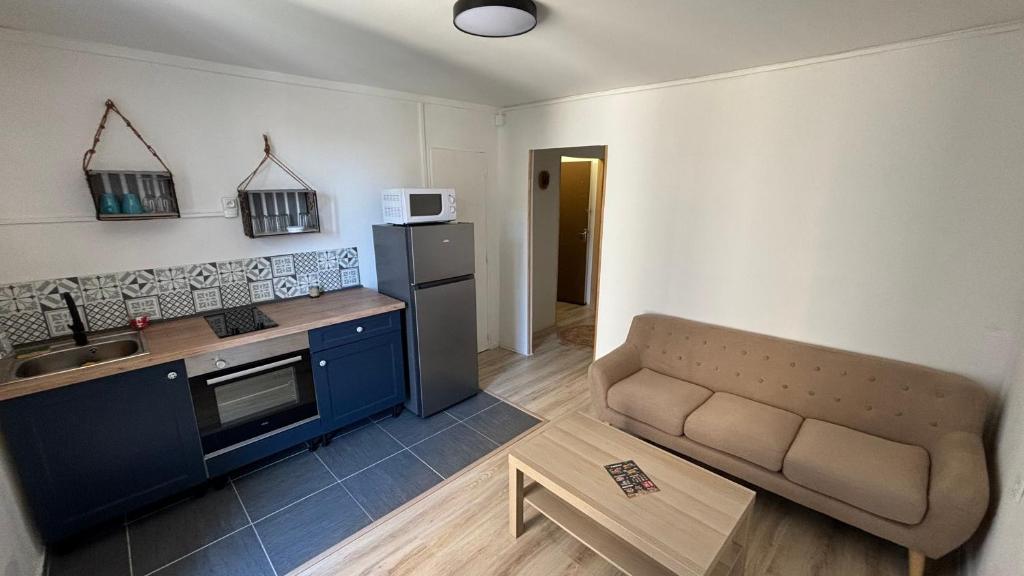 a kitchen with a couch in a small room at Bel appartement cœur de village in Saint-André-de-Sangonis
