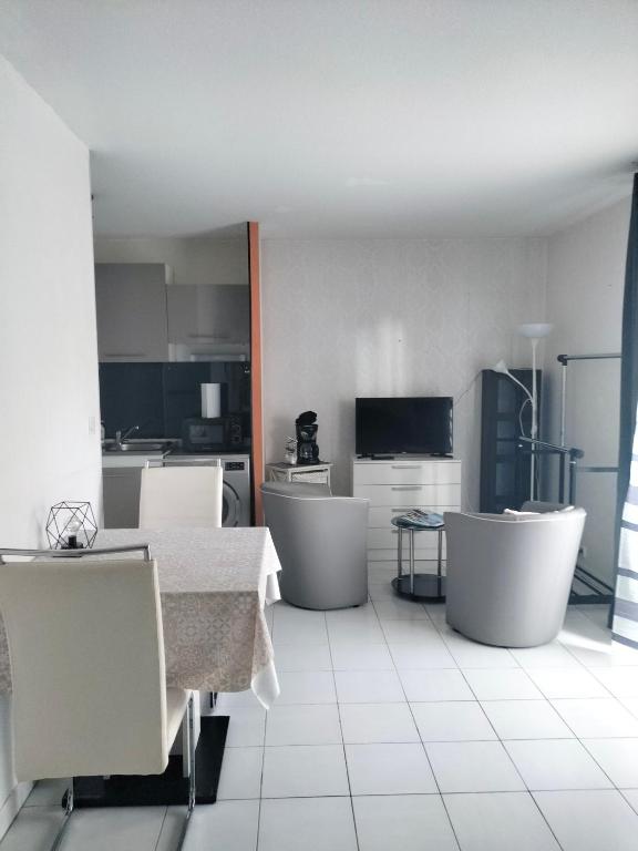 une cuisine avec une table et des chaises dans une pièce dans l'établissement Studio proche gare Saint brieuc, à Saint-Brieuc
