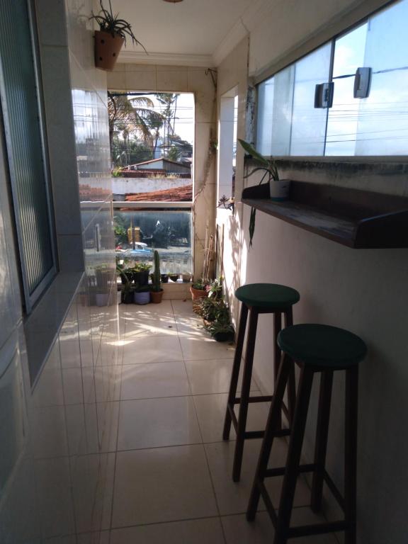 a room with two bar stools and a window at Maracaípe Cantinho Vida Boa in Porto De Galinhas