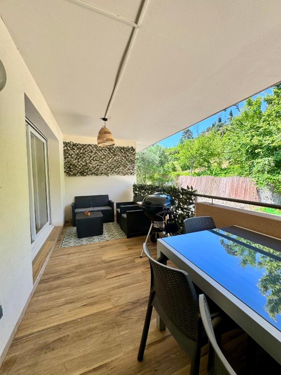 une pièce avec une table et des chaises et une grande fenêtre dans l'établissement Appartement T3 avec terrasse et parking dans petite résidence fermée et calme , proche de toutes commodités, à Marseille