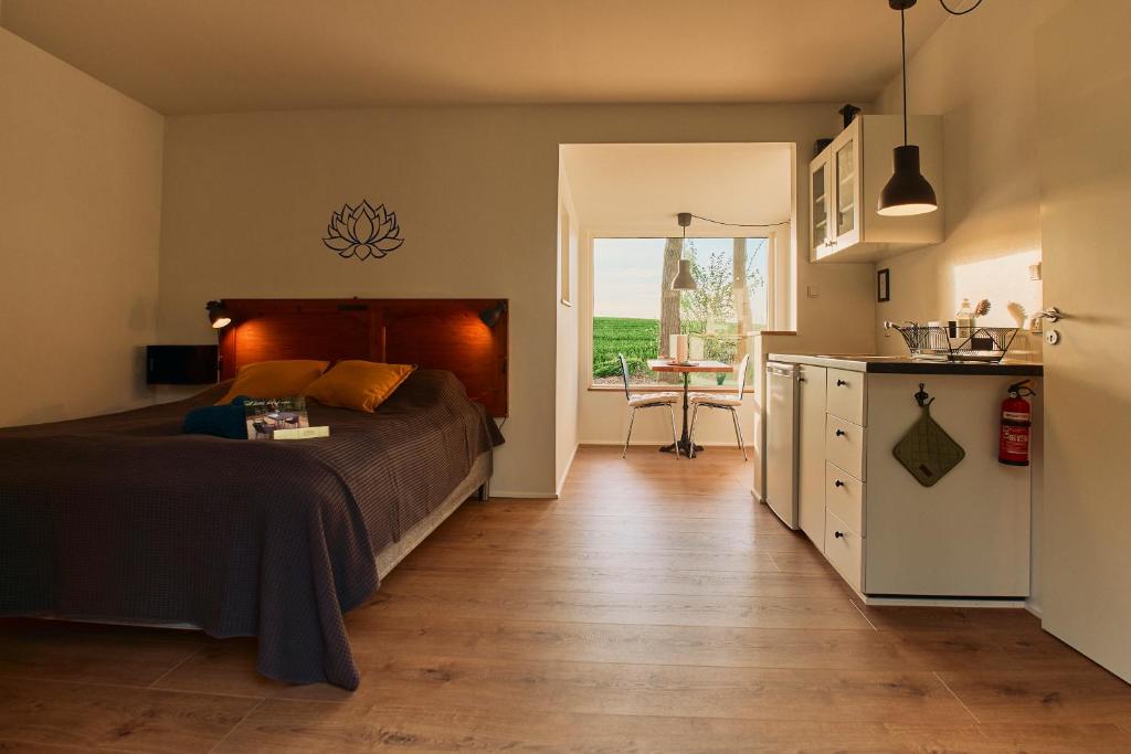 una camera da letto con un letto e una cucina con un tavolo di Ferieidyl a Kettinge