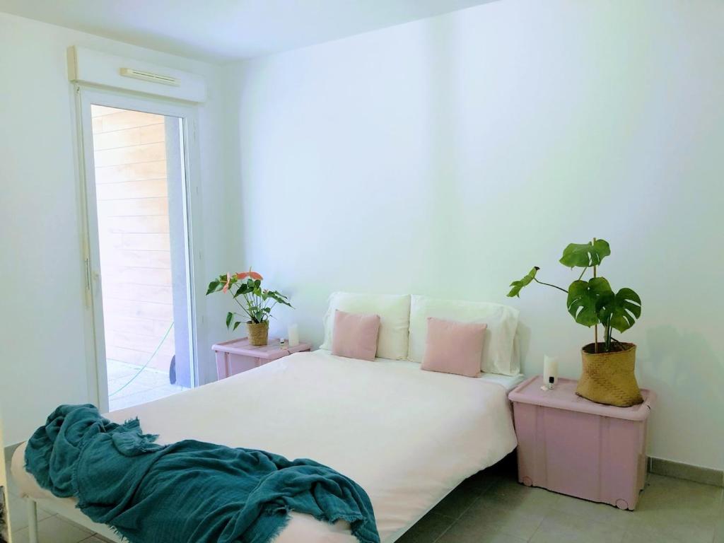 - une chambre avec un grand lit blanc et 2 plantes dans l'établissement Marseille, nature and the good life, à La Celle-sous-Gouzon