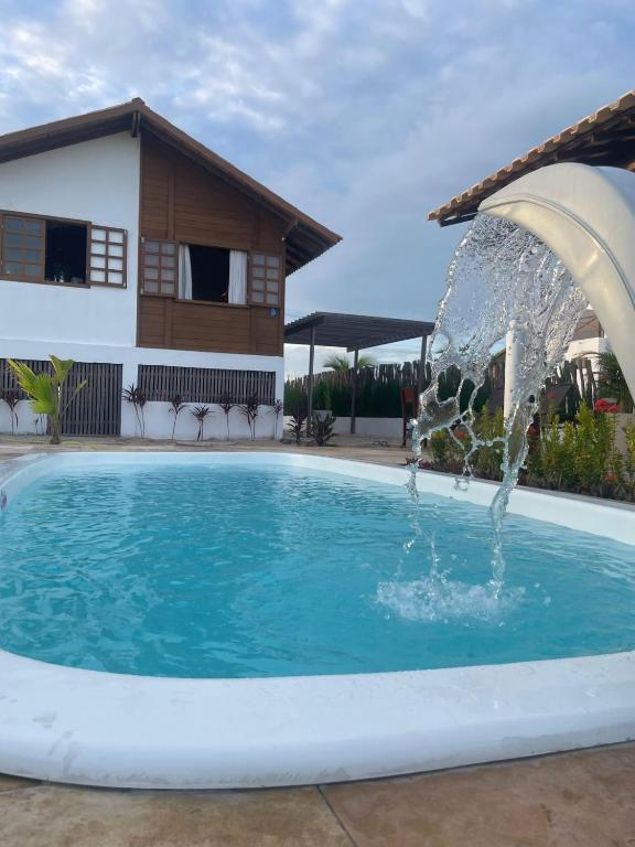 a swimming pool with a water fountain at Chalé Bela Vista in Tatajuba