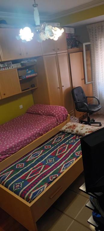 une chambre avec un lit et une chaise dedans dans l'établissement Habitacion doble, à Portugalete