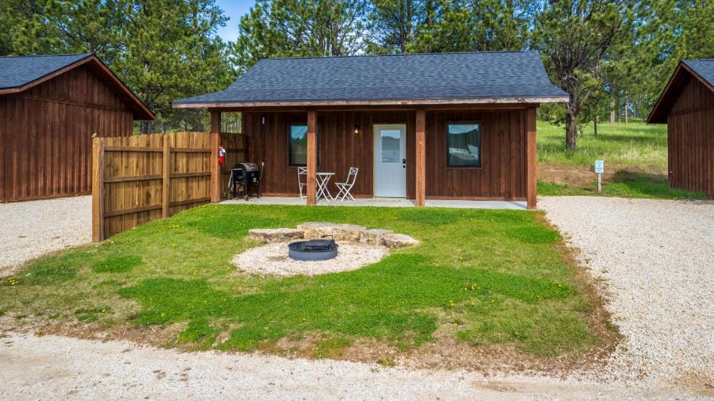 a small cabin with a fire pit in the yard at Gold Valley Camp Cabin 2 in Custer