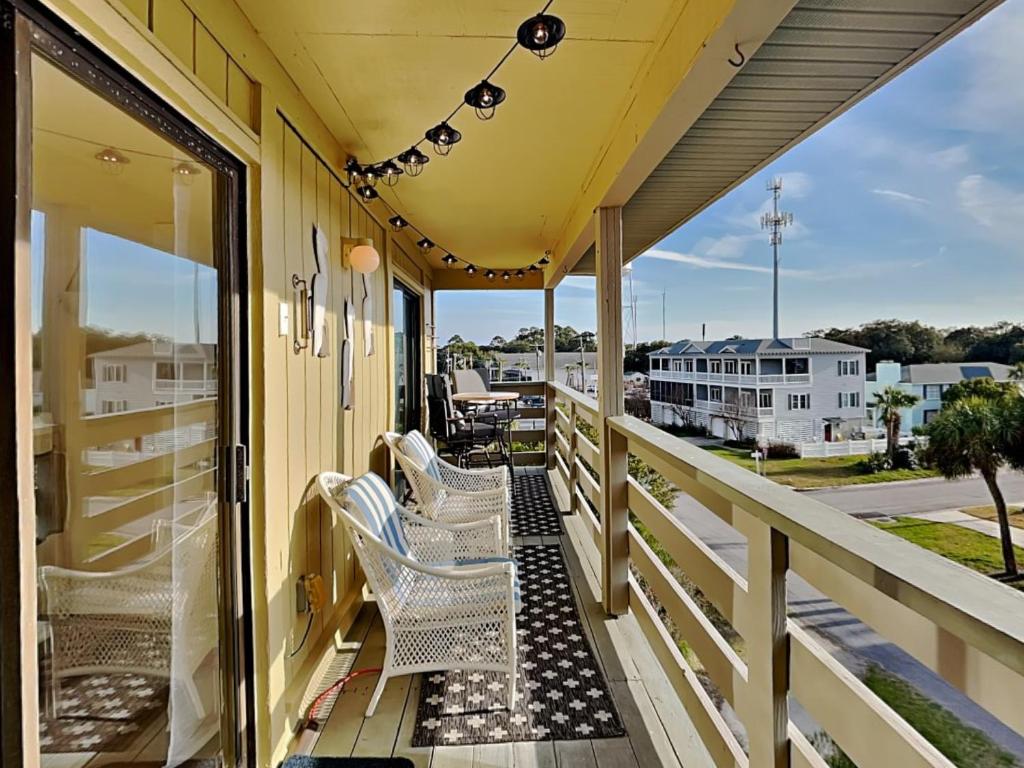 un porche avec des chaises et une vue sur une rue dans l'établissement Lighthouse Point 7C, à Tybee Island