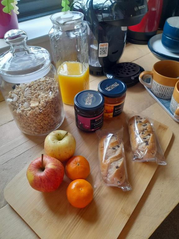 a table with apples oranges oranges and other food items at Double room, living space and bathroom, in a family home, near Ulverston in Pennington