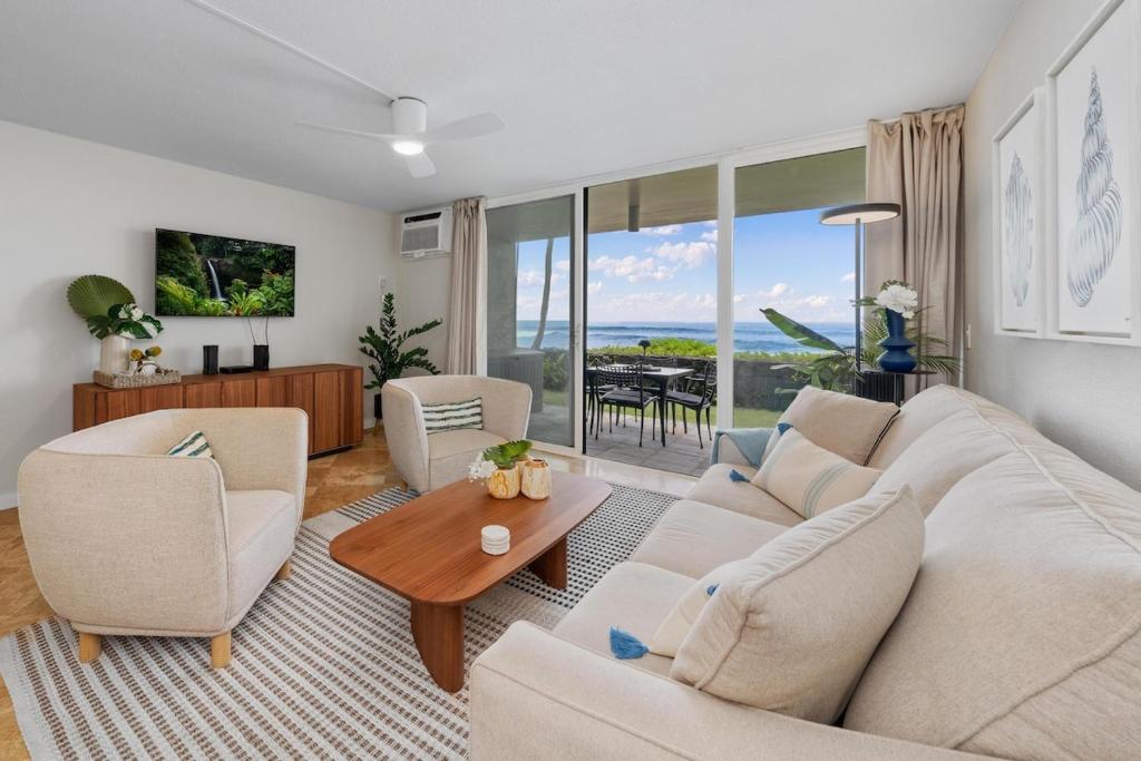 un salon avec un canapé, des chaises et une table dans l'établissement Oceanfront Condo Kailua Kona Walk to Beach Town and Sunset Views, à Kailua-Kona