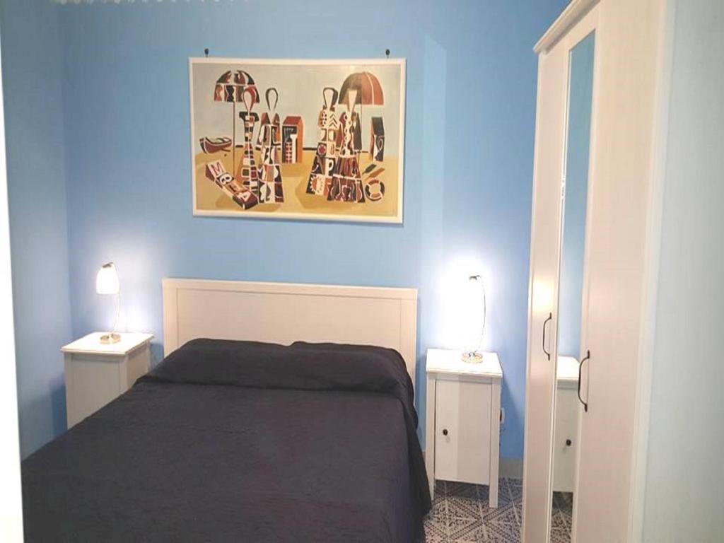 ジャルディーニ・ナクソスにあるBilocale Nefeleの青いベッドルーム(ベッド1台、ナイトスタンド2台付)