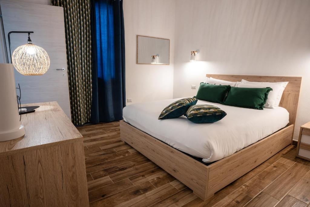 a bedroom with a bed with green pillows on it at Alessandra's apartment in Sassari