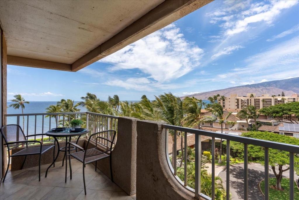 a balcony with a table and chairs and the ocean at Nani Kai Hale 604 by Coldwell Banker Island Vacations in Kihei