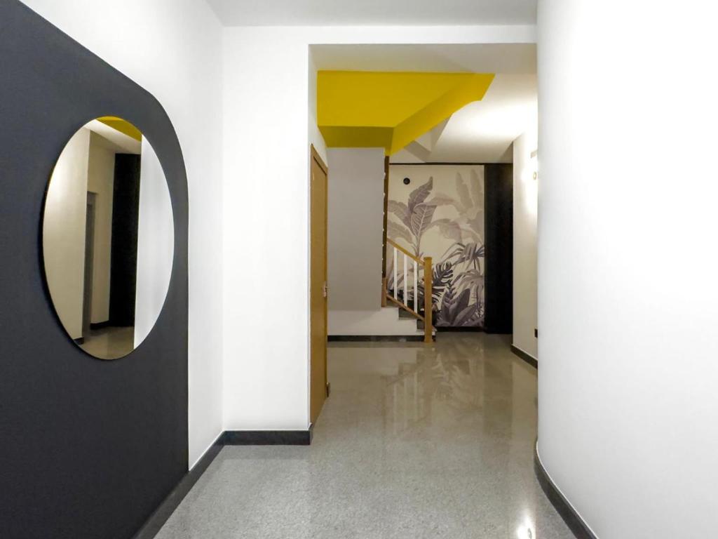 a hallway with a round mirror and white walls at Atticus in Toledo