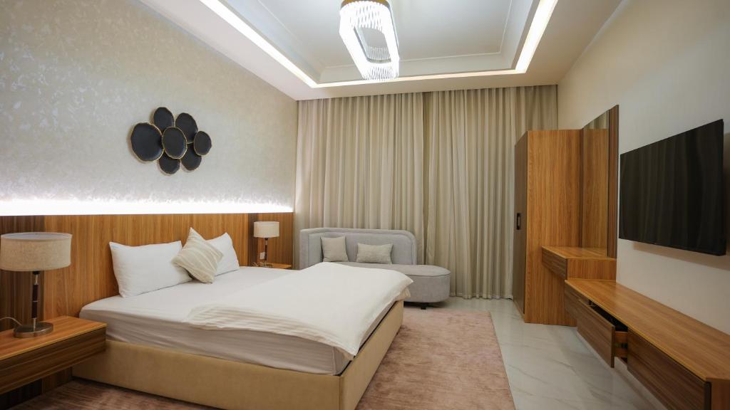 a bedroom with a bed and a television in it at مجمع شاليهات هيلز in Salalah