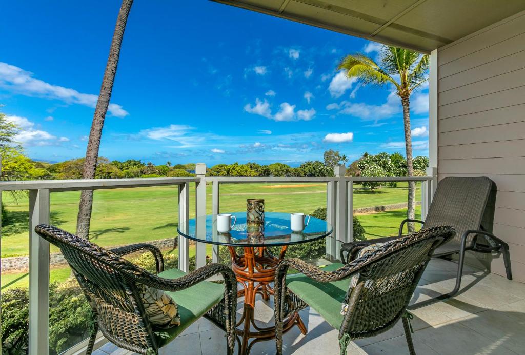 a patio with a table and chairs and palm trees at Grand Champions 145 by Coldwell Banker Island Vacations in Wailea