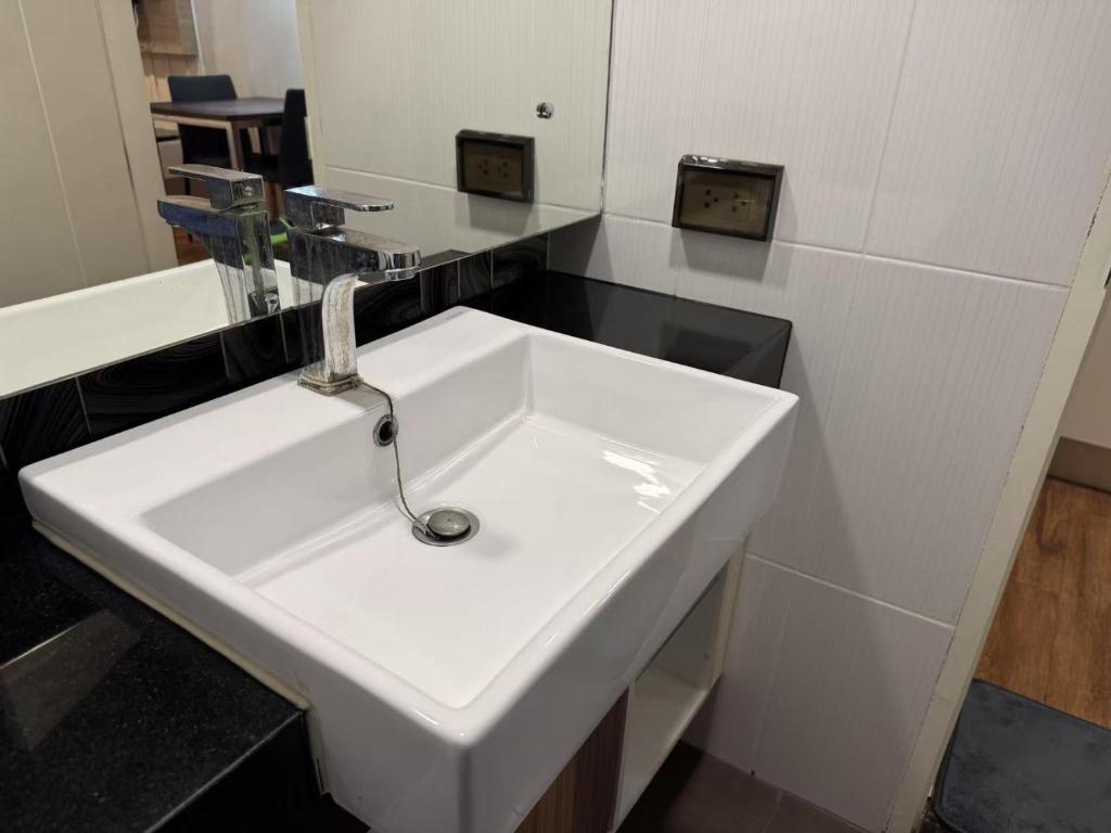 a white sink in a bathroom with a mirror at Dusit Grand Park 1 in Jomtien Beach