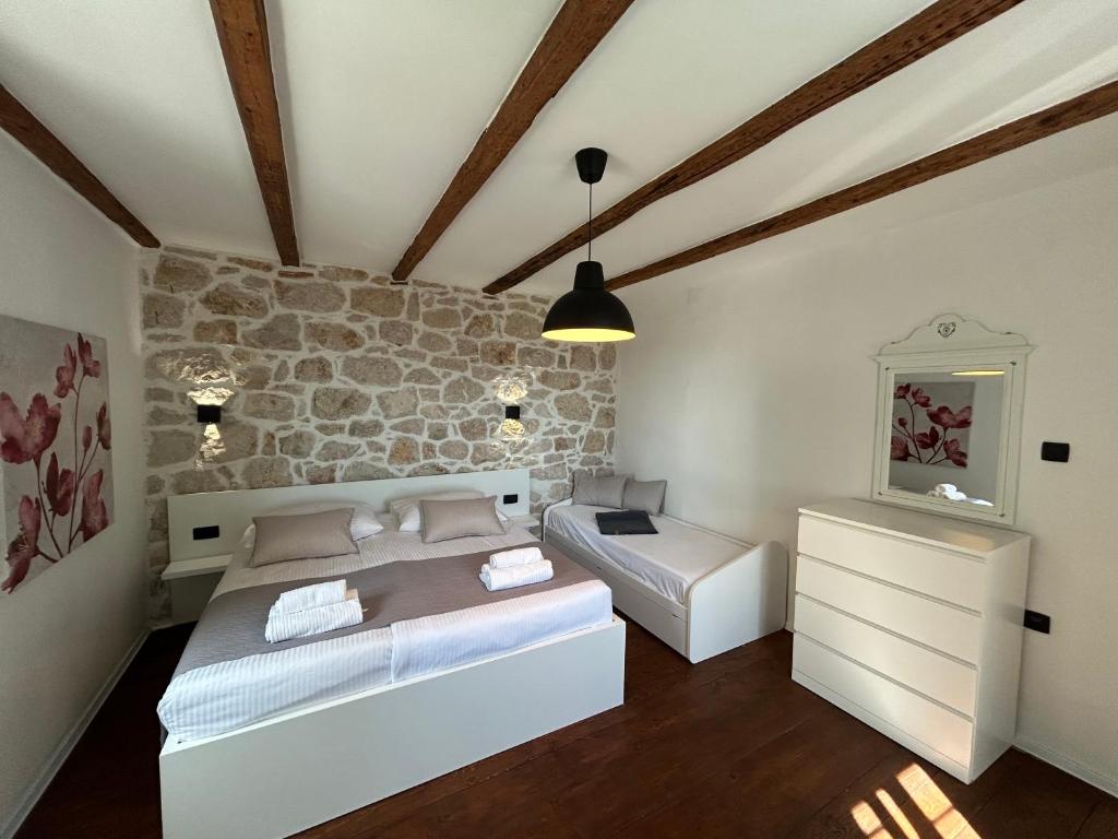 Postel nebo postele na pokoji v ubytování Holiday house Pantovčak, secluded stone house with heated pool and unique view