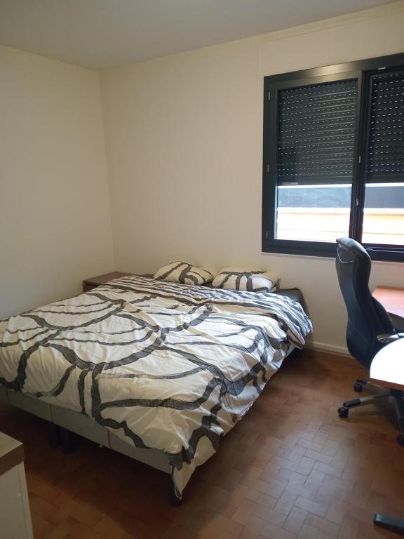a bedroom with a bed and a chair and a window at Studio annonay in Annonay