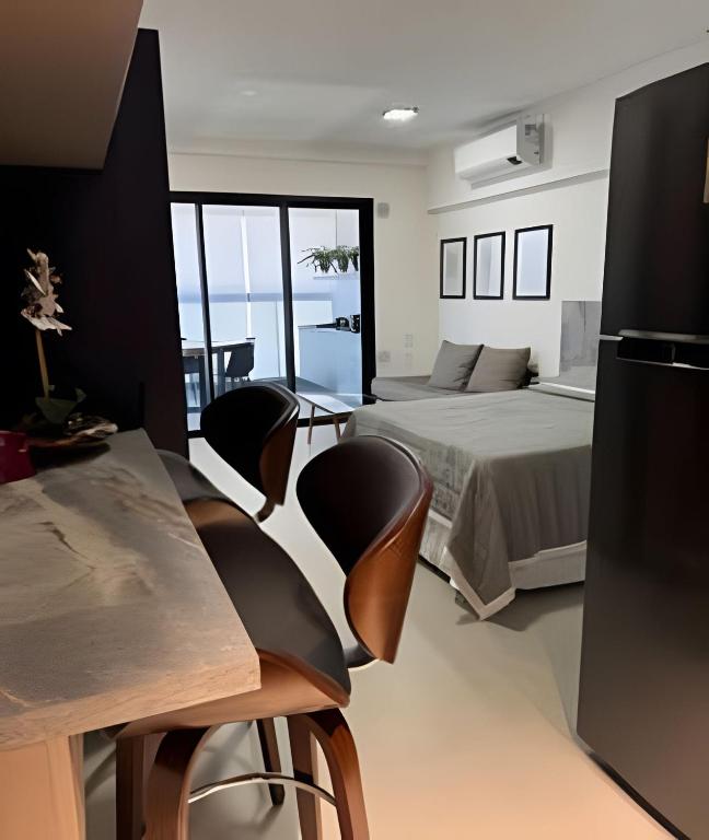 a bedroom with a bed and a table and chairs at Studio Concept Avenida das Esmeraldas in Marília