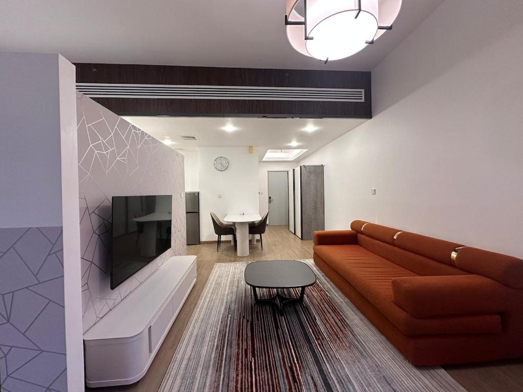 a living room with a couch and a table at Cozy Studio Apartment in Dubai