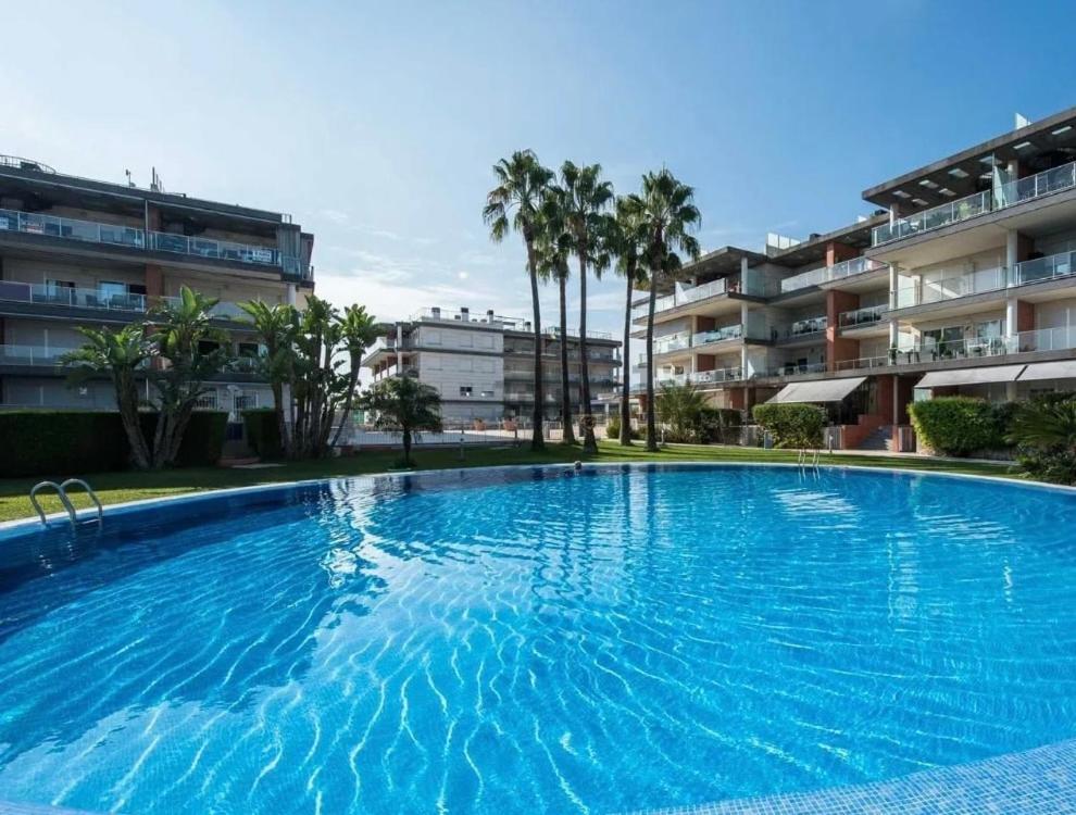 ein großer blauer Swimmingpool vor einem Gebäude in der Unterkunft Albatros Apartment met-golf-beach in Oliva