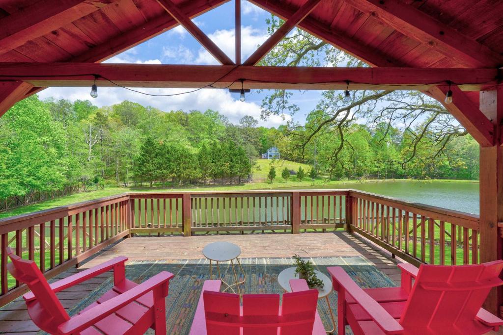 eine abgeschirmte Veranda mit roten Stühlen und einem Tisch in der Unterkunft Lake Views Hot Tub Fire Pit 6bed in Morganton