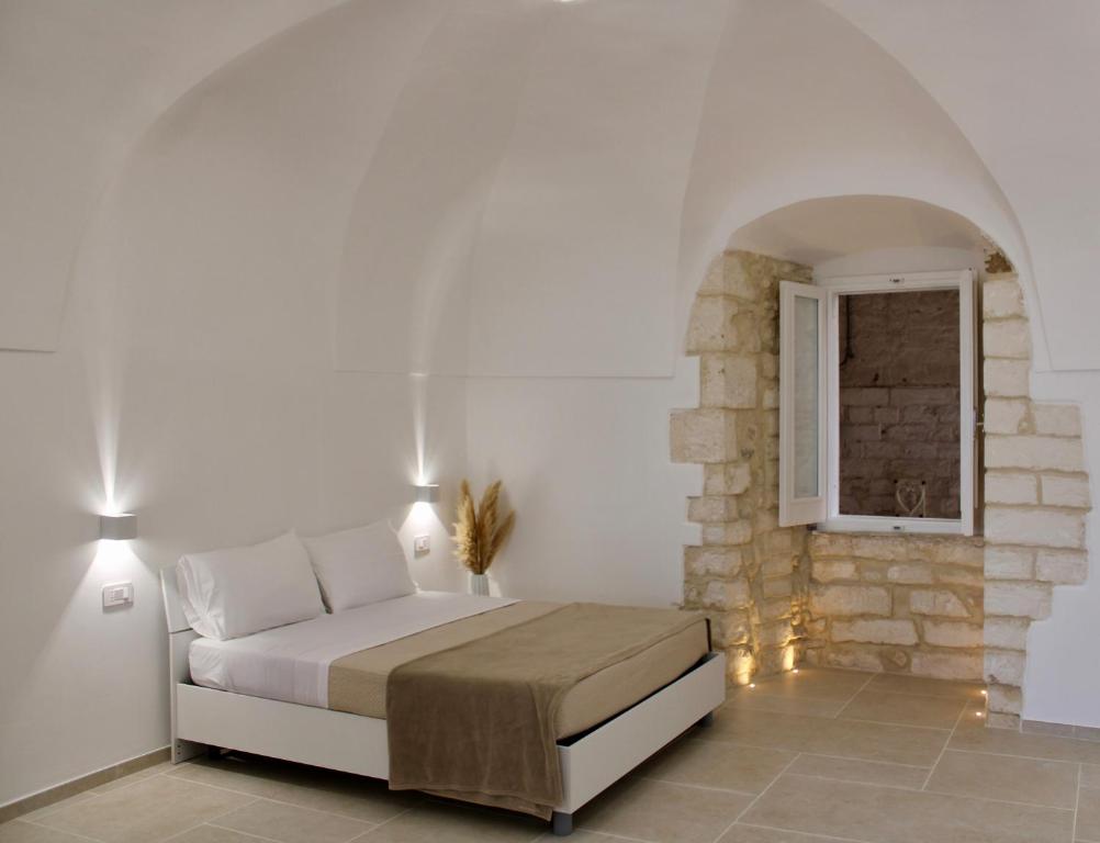 a bedroom with a bed and a stone wall at Maison al Duomo in Vieste