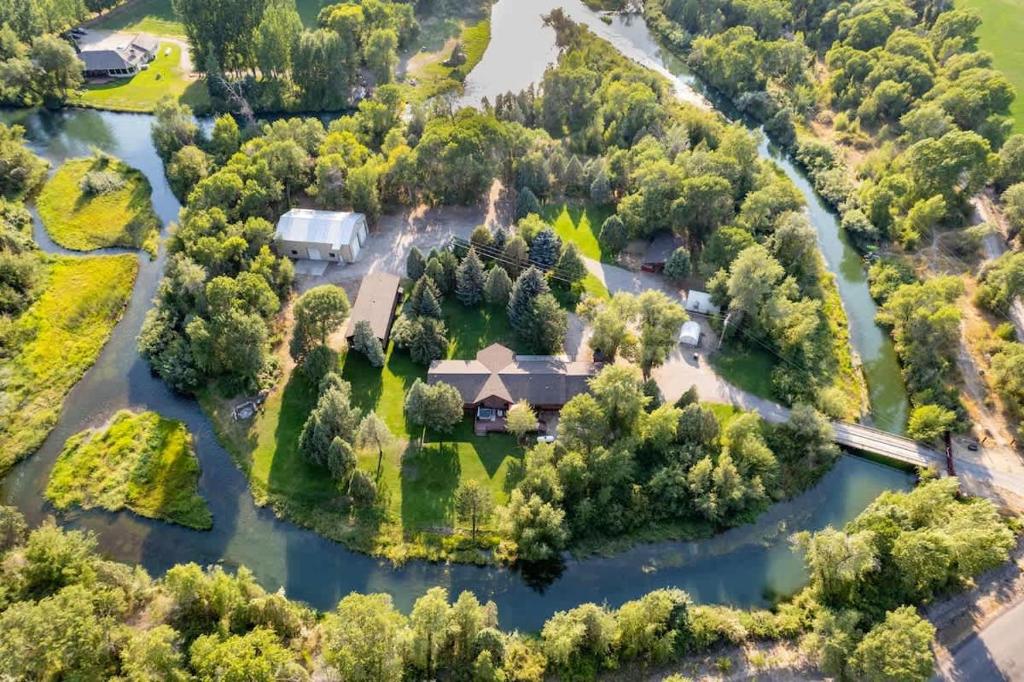 an aerial view of a house on an island in a river at Private Island Fire Pit & Arcade in Rigby