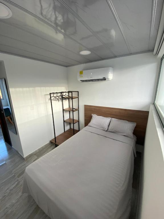 a bedroom with a white bed in a room at Edificio Cardamomo - Apartaestudio 205 in Neiva