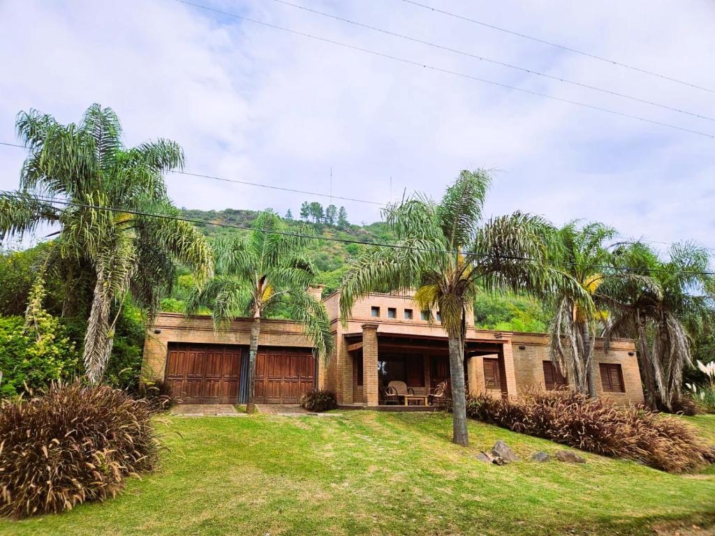 a house with palm trees in front of it at Casa de Categoría con Losa Radiante en Embalsina, Villa del Dique, Calamuchita, Córdoba in Villa del Dique