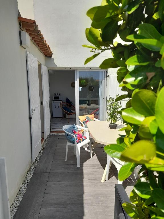 un patio avec une table et une table et des chaises dans l'établissement Appartement cosy et lumineux à 50 m de la plage, au Cap d'Agde
