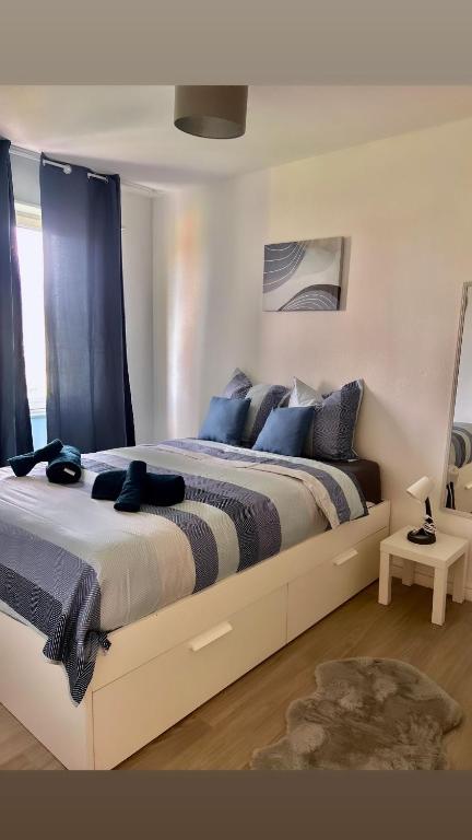 une chambre avec un grand lit avec des oreillers bleus dans l'établissement A deux pas du musee de l automobile, à Mulhouse