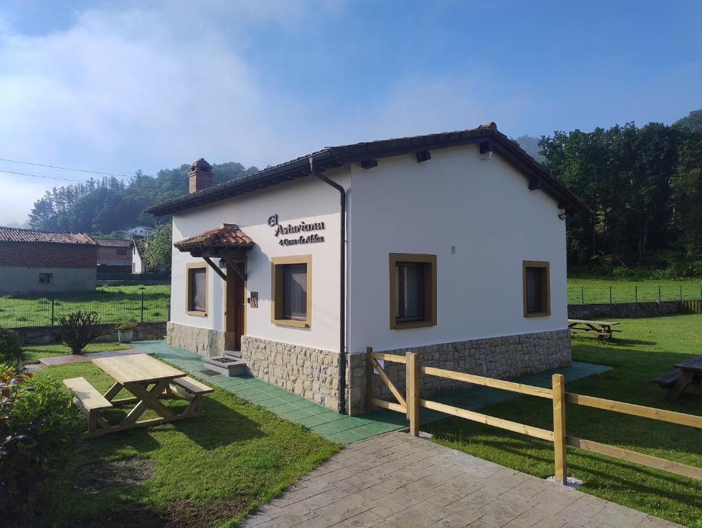 a small white building with a picnic table in front of it at El Asturianu in Cangas de Onís