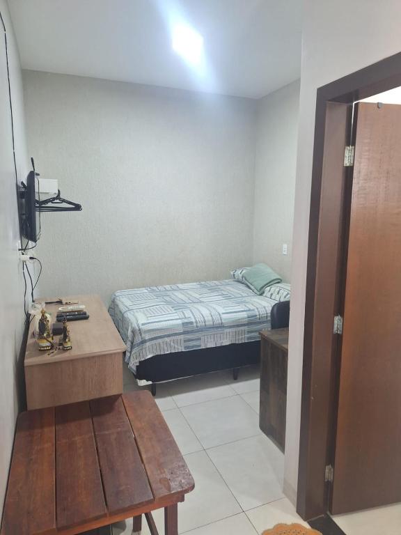 a bedroom with a bed and a table and a bench at Apartamento vest unirv in Rio Verde