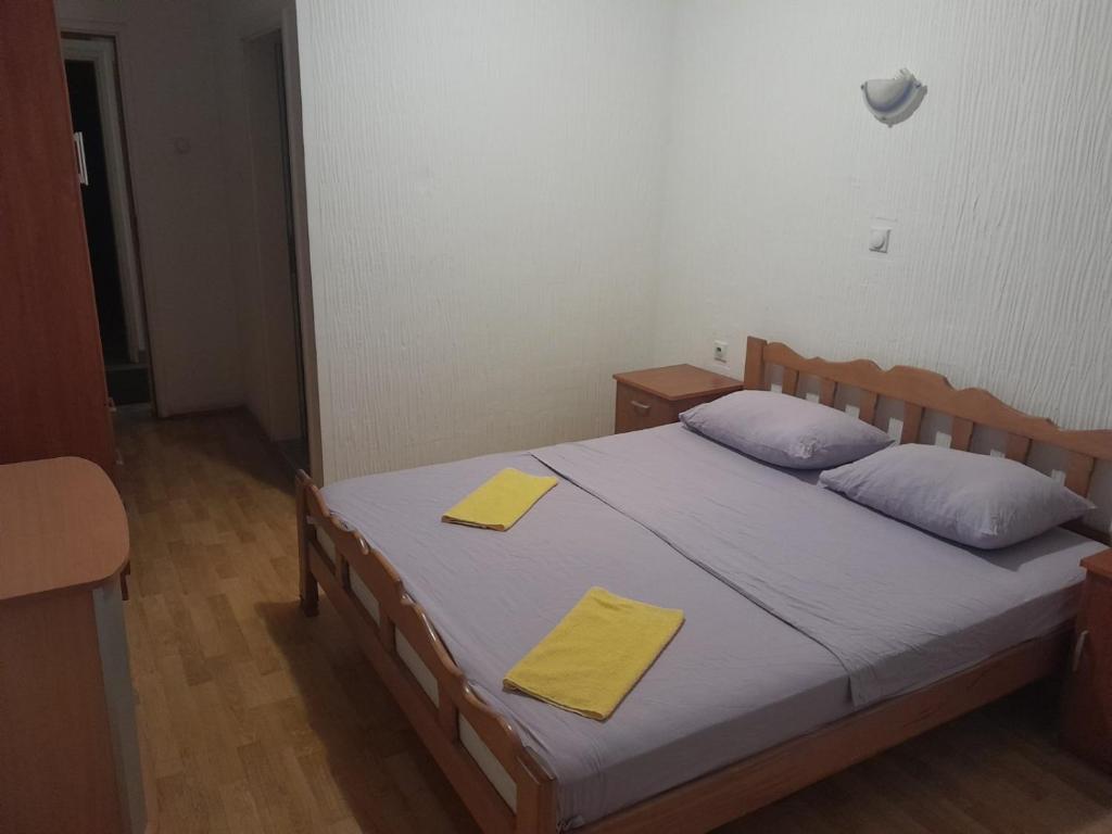 a bedroom with a bed with two yellow towels on it at Motel Tara in Mojkovac