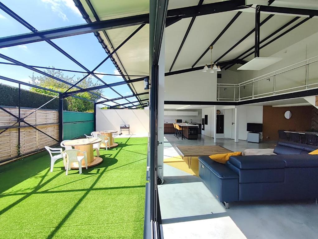 un salon avec un canapé et une table dans l'établissement Loft lumineux, pièce de vie 100m2, parking privé, à Le Mesnil-Esnard