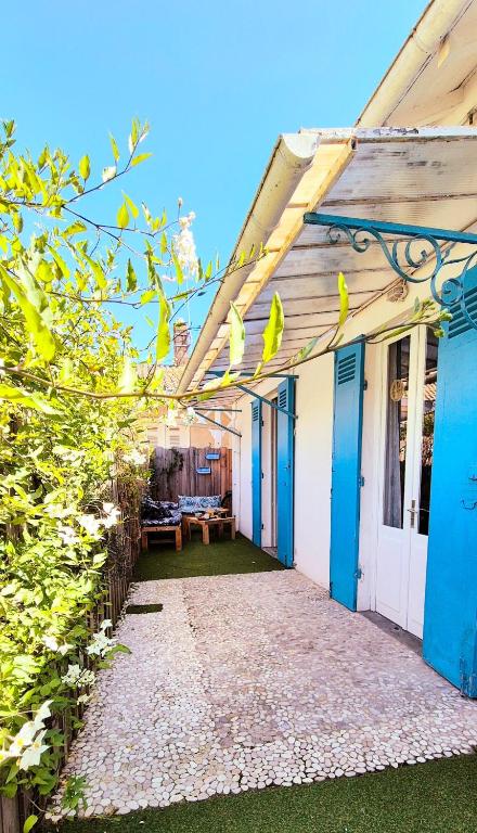 une terrasse couverte d'une maison avec portes bleues dans l'établissement La Maison des Piranhas, à Arcachon