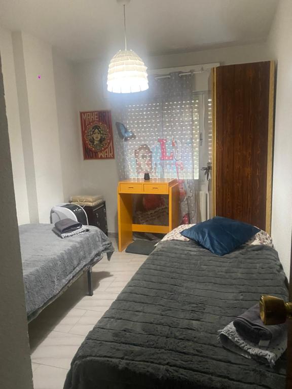 a bedroom with two beds and a yellow cabinet at Paris in Alcalá de Henares