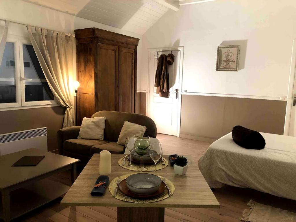 a living room with a bed and a coffee table at Studette proche Meaux-Disneyland-A4 in Saint-Jean-les-Deux-Jumeaux
